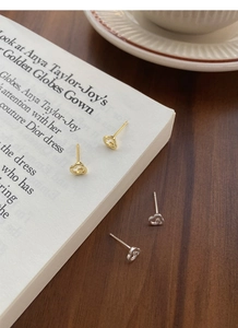 Vue détaillée de boucles d'oreilles cœur en argent et or avec un design ajouré texturé