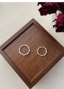 Detail view of two S999 silver Mobius rings with matte finish on a vintage wooden tray