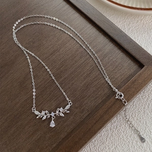 S925 sterling silver wheat leaf necklace with teardrop zircon on rustic wood tray