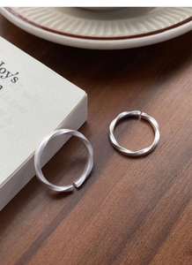 Macro view of Mobius sterling silver rings with matte finish on a wooden background
