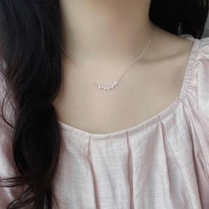 Collier feuille de ginkgo en argent 999 avec zircons délicats porté par un modèle