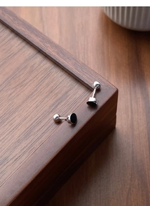 Détail de boucles d'oreilles en argent S999 avec incrustation d'émail noir rond épuré