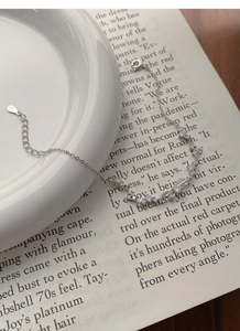 Detailed view of S999 sterling silver bow bracelet with sparkling zircons and S925 tag