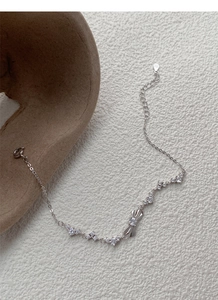 Macro shot of S925 silver bracelet featuring a bow charm and sparkling cubic zirconia