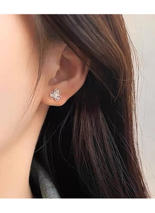 Macro shot of S999 sterling silver clover stud earring with zircons worn on model