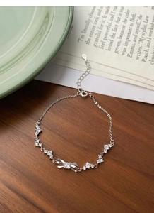Detail of S925 silver bow bracelet with sparkling zircons and lobster clasp closure