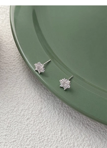 Close-up of S925 sterling silver hallmark on sparkling snowflake zircon stud earrings