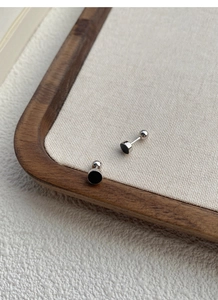 Détail de boucles d'oreilles en argent S999 avec émail noir et fermoirs à bille vissés