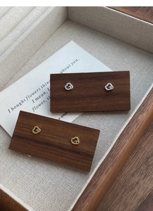 Gros plan de boucles d'oreilles nuages en argent sterling S999 sur support bois