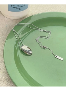 Detail showing S925 hallmark on minimalist silver oval pendant necklace with polished finish