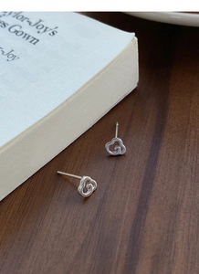 Vue détaillée des boucles d'oreilles nuages évidés en argent S999 sur un bureau en bois