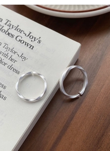Macro view of matte S999 silver Mobius rings with brushed texture on a vintage book