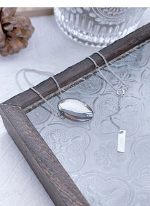 Detailed macro view of S925 sterling silver oval pendant and hallmark on fine chain