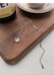 Dettaglio della collana in argento S999 con pendente in calcedonio bianco a forma di prugna