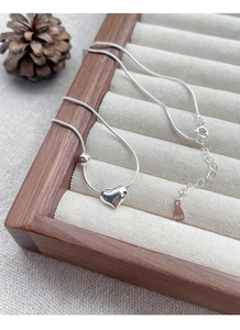 Detail of S925 sterling silver heart necklace on wooden tray with S925 hallmark stamp