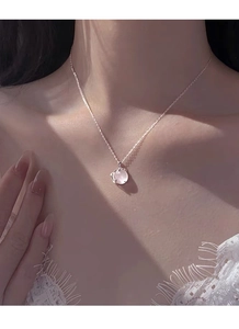Primo piano della collana in argento S999 con calcedonio bianco su una modella donna