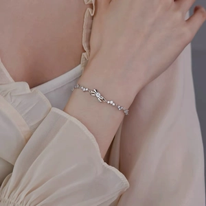 Elegant S999 silver bow bracelet with sparkling zircons worn on a female wrist