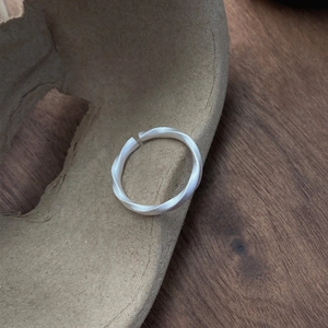 Minimalist S999 silver Mobius ring with matte twisted texture and adjustable open band