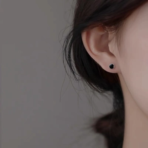 Boucles d'oreilles clous rondes en argent S999 et émail noir portées sur l'oreille