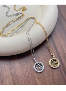 Gros plan de colliers pendentifs Fu en argent S925 avec zircons en finitions or et argent