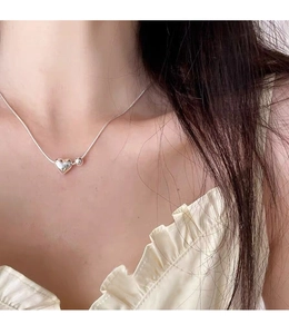 Macro view of sterling silver heart pendant necklace on a delicate snake chain