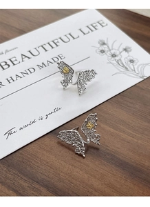Detail showing S925 silver butterfly earrings with hollow pattern and gold flower accent