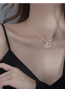 Vue détaillée d'un collier en argent sterling S925 avec pendentif Fu évidé au cou