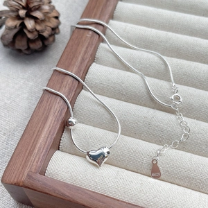 Elegant S925 sterling silver heart necklace with snake chain on a jewelry tray