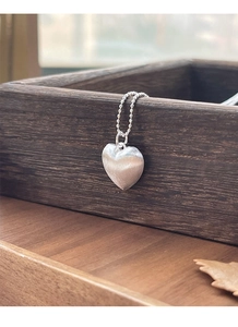 Dettaglio macro della collana a cuore in argento sterling S925 con finitura opaca spazzolata