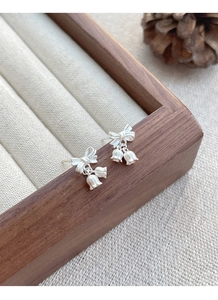 Macro detail of S925 silver lily of the valley earrings with bowknot and bell-shaped buds