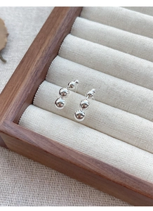 Close-up of S925 sterling silver triple bead earrings in a jewelry display box