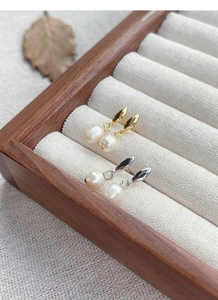 Détail de clous en argent en forme de feuille avec perles d'eau douce blanches et dorées