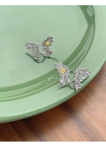 Macro detail of S925 sterling silver butterfly earrings with vintage carved textures