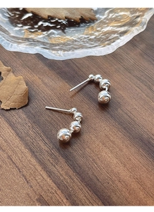 Macro detail of four minimalist S925 sterling silver beads in a curved gradient design