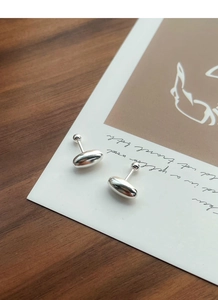 Detailed view of polished S925 sterling silver oval bean earrings with screw back ball
