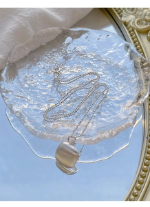 Vue détaillée du pendentif carré en argent S925 avec finition mate sur verre à ondulations
