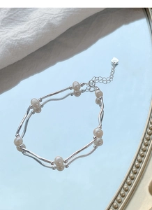 Detail of S925 sterling silver tube bracelet featuring pearls and heart charm