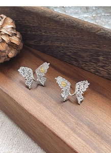 Detailed macro of S925 silver butterfly earring with intricate hollow patterns