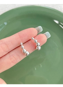 Macro shot of curved S925 sterling silver minimalist geometric bead stud earrings