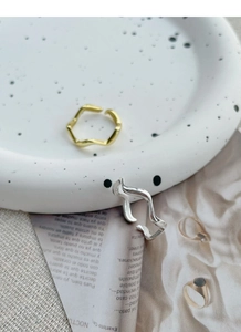 Detailed view of wave-shaped S925 sterling silver rings in gold and silver finishes