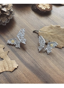 Close-up of vintage S925 silver butterfly earrings with golden floral motifs