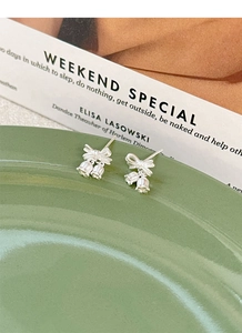 Detailed close-up of S925 silver lily of the valley stud earrings with bow tie design