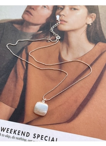 Détail du pendentif carré en argent S925 avec finition brossée mate et chaîne à billes fine