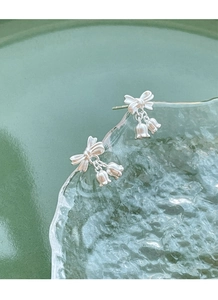 Macro shot of S925 sterling silver lily of the valley earrings with bow details