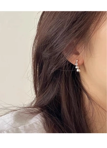 Macro shot of S925 sterling silver geometric bead earrings on a model's earlobe