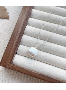 Détail macro du pendentif carré minimaliste en argent sterling S925 avec texture brossée