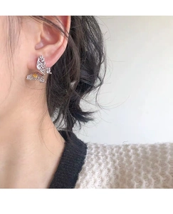 Detail of S925 sterling silver butterfly earring with yellow gemstone on model's ear