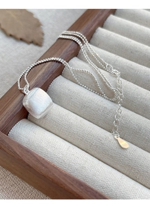 Détail du pendentif carré en argent S925 avec finition brossée dans un écrin à bijoux