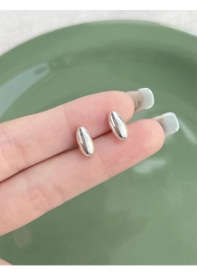 Macro shot of S925 sterling silver oval bean stud earrings with polished finish
