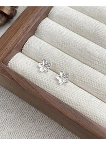 Macro shot of S925 sterling silver flower stud earrings with brushed metal finish